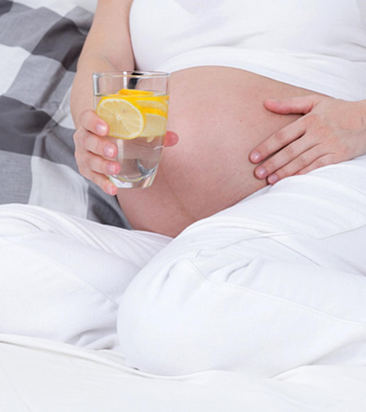 A pregnant lady drinking lemon water
