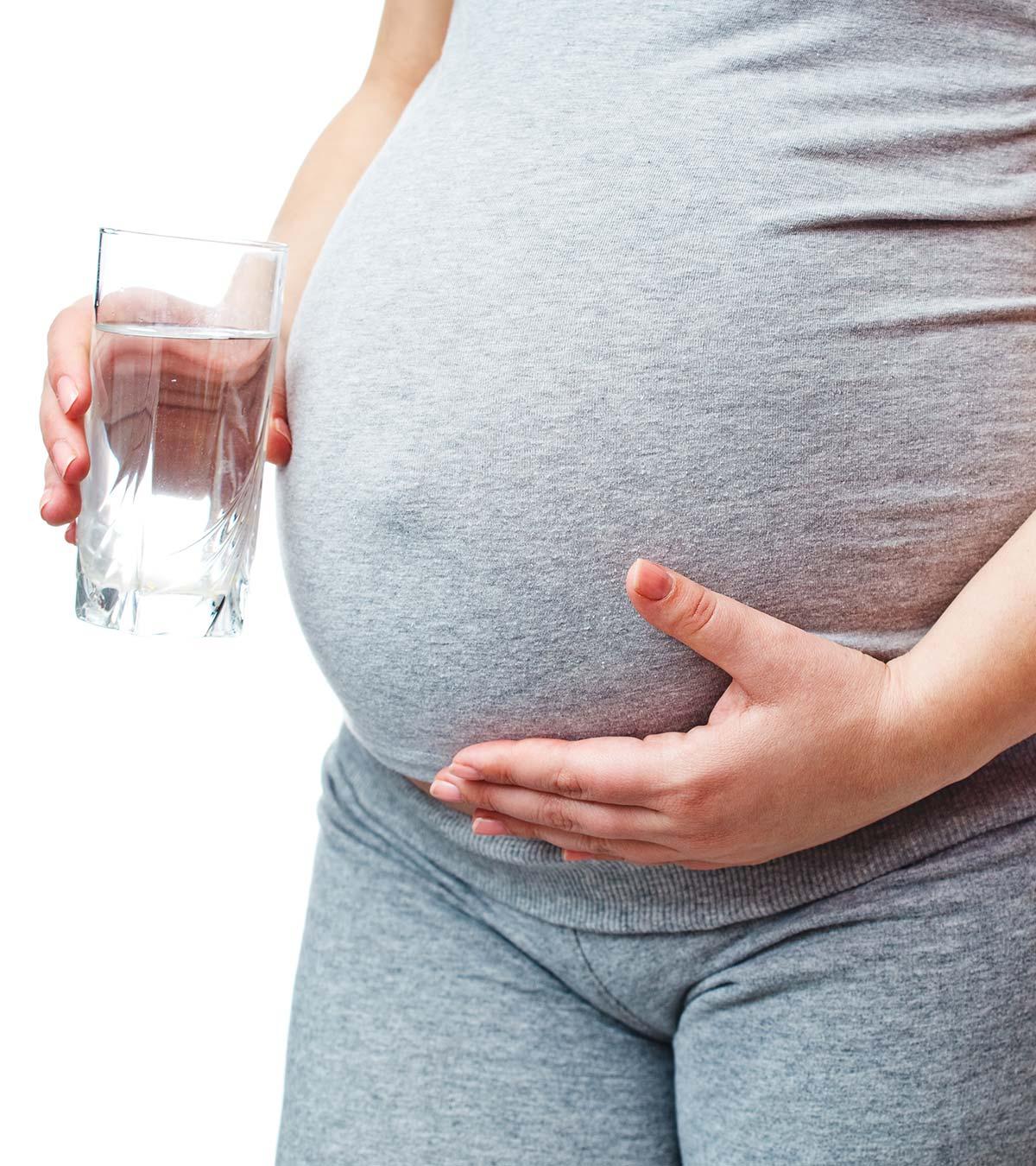 A pregnant lady drinking hot water