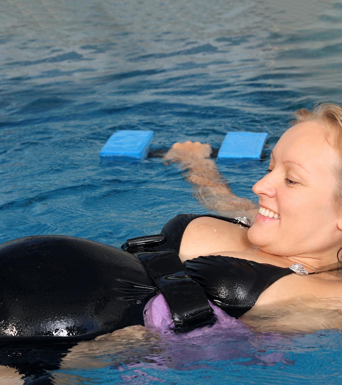 A pregnant lady swimming in a swimming pool