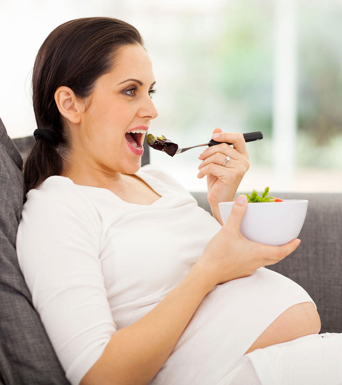 A pregnant lady eating liver with a spoon