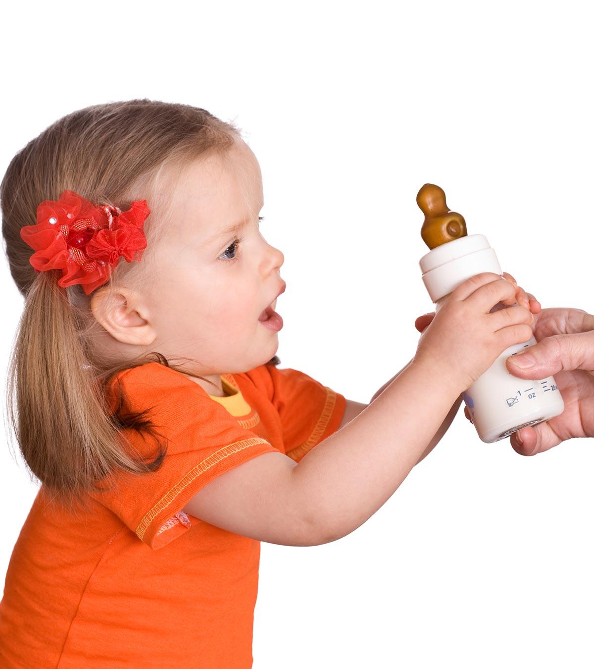 A mom giving a milk bottle to her baby