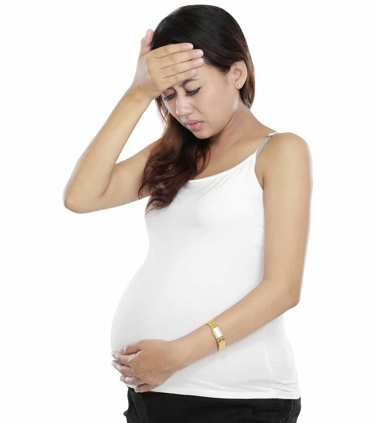 Pregnant woman holding her stomach, discussing symptoms of E. coli infection