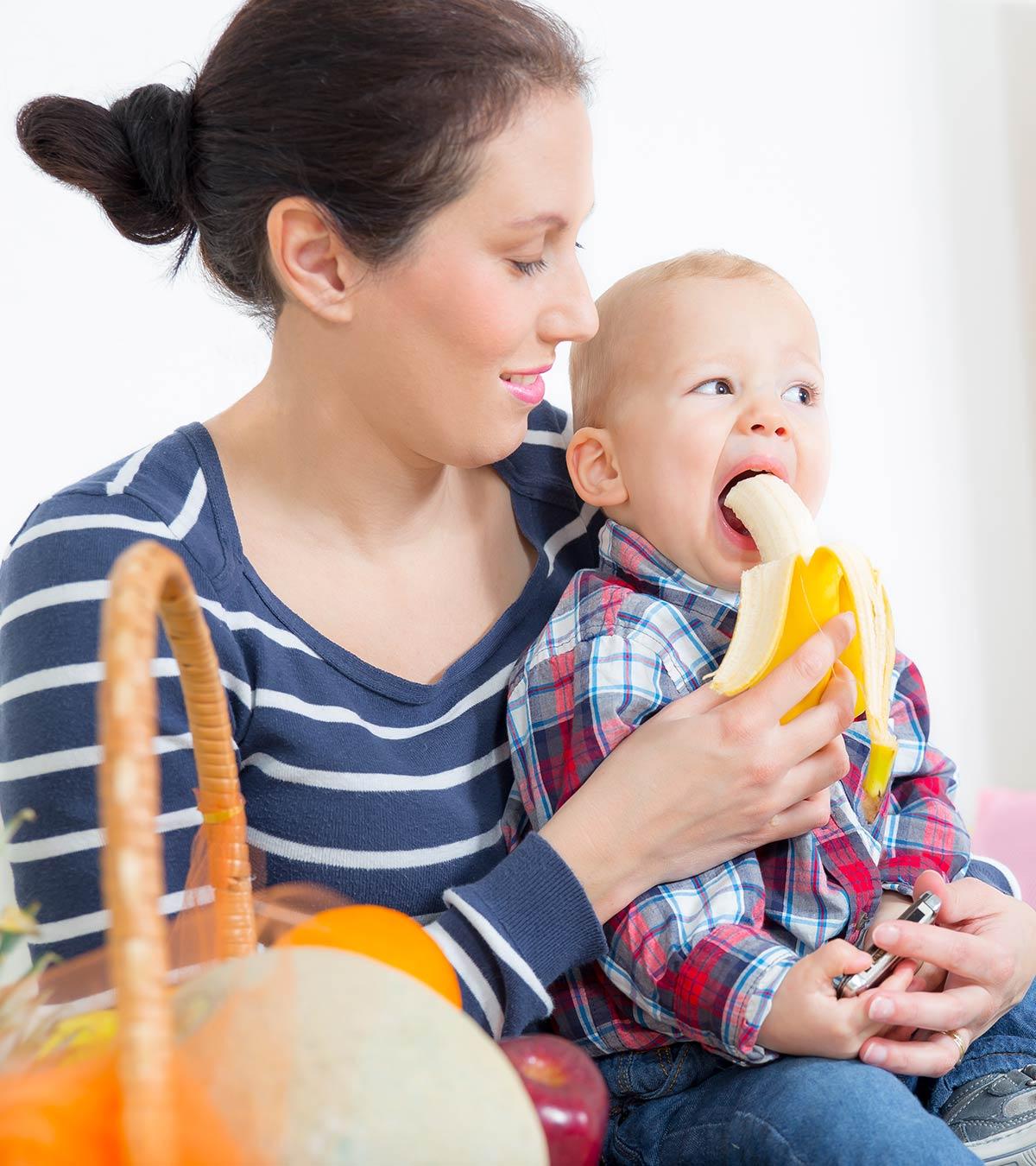 A Mother Feeding Banana To Her Baby