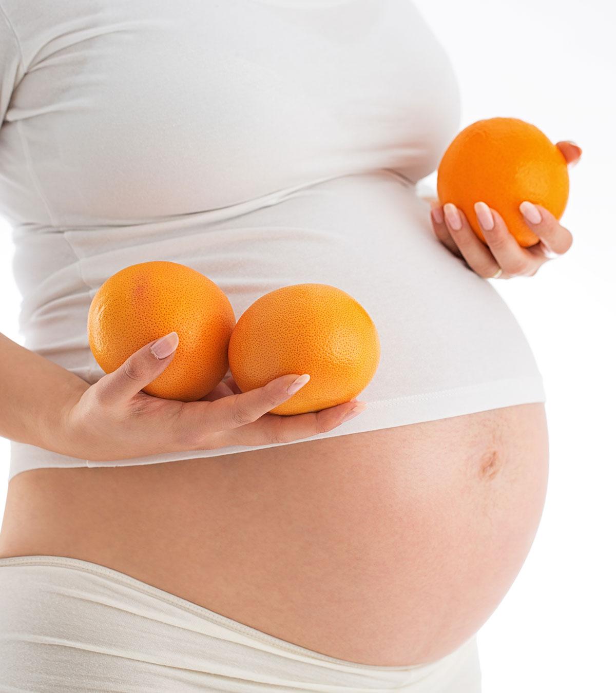 Pregnant woman eating fruits rich in vitamin C