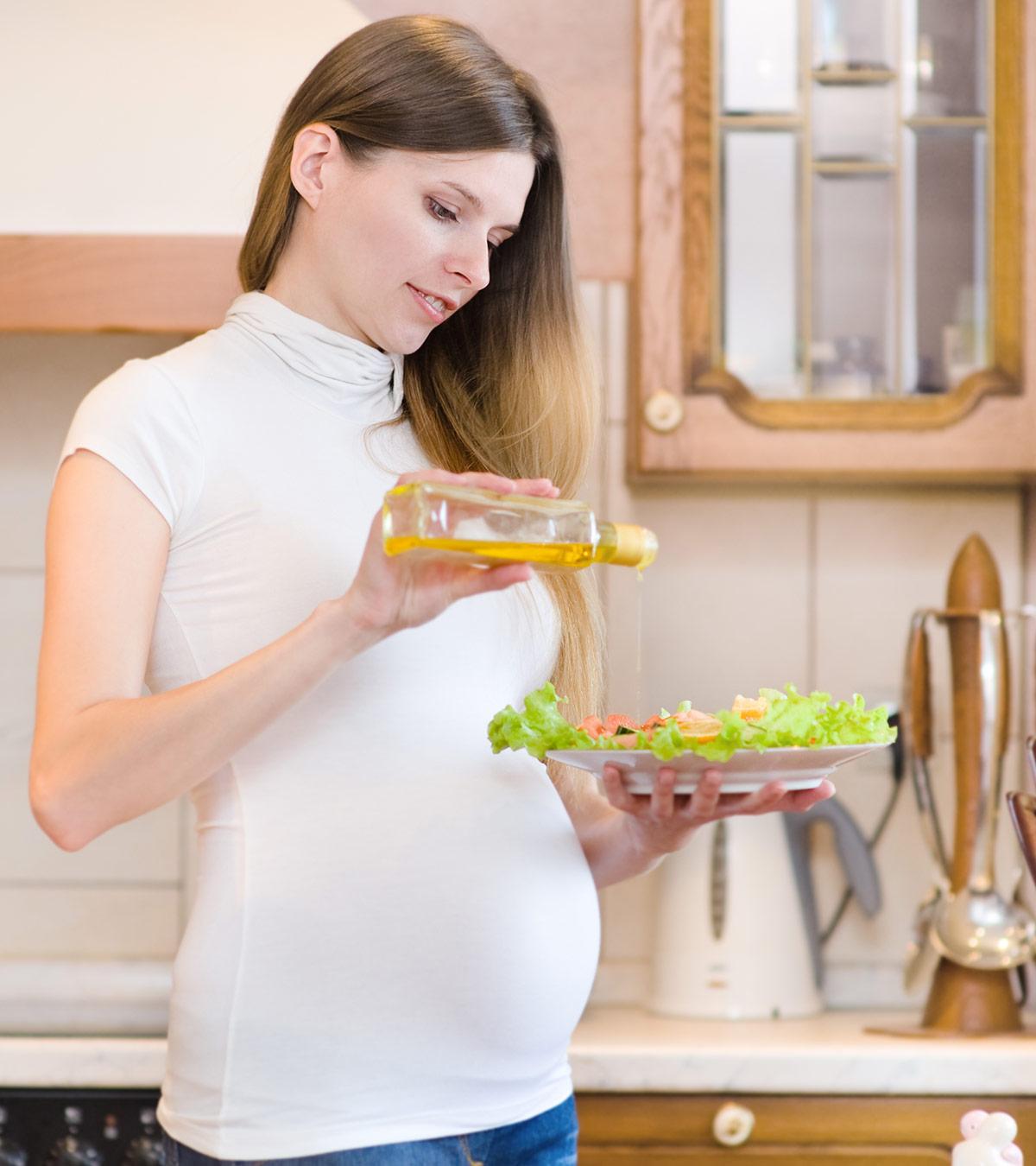 A pregnant lady adding olive oil to her foods