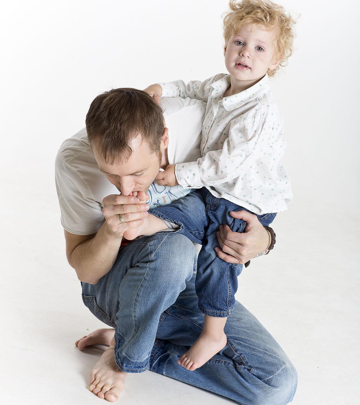 A Father Removing Splinter In His Toddler