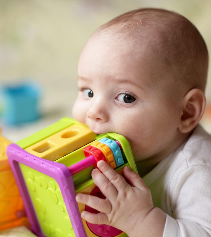 A baby biting his toys