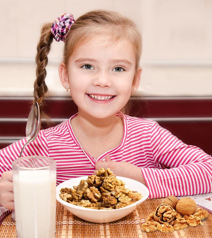 A kid eating some walnuts and drinking milk