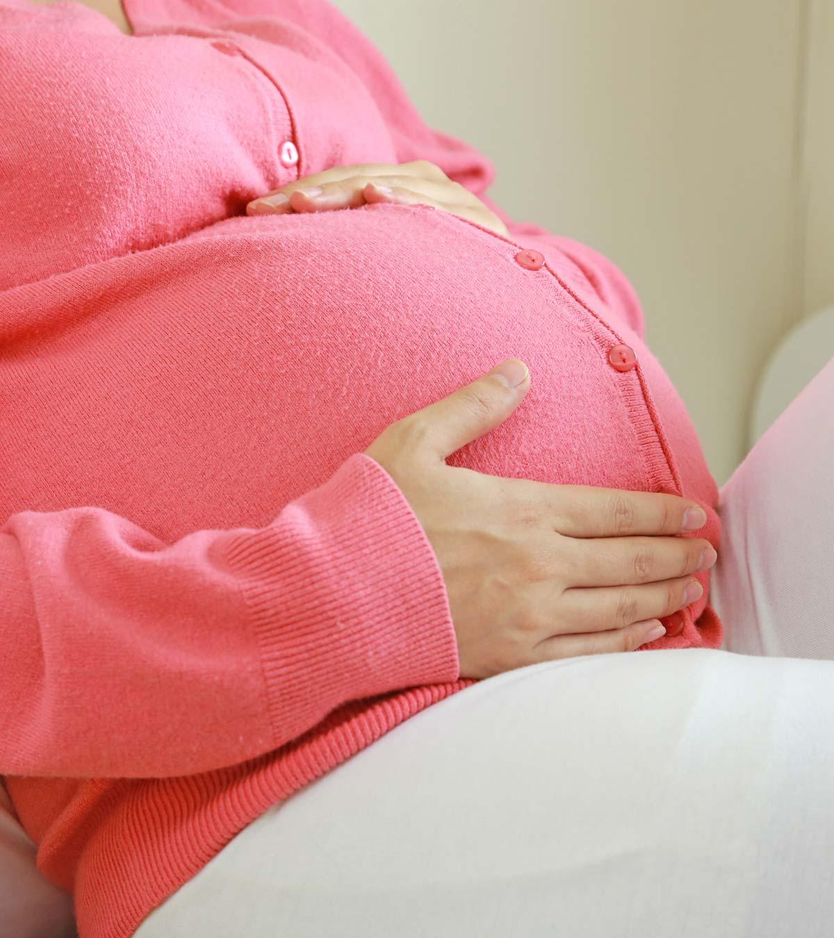 A pregnant holds her womb
