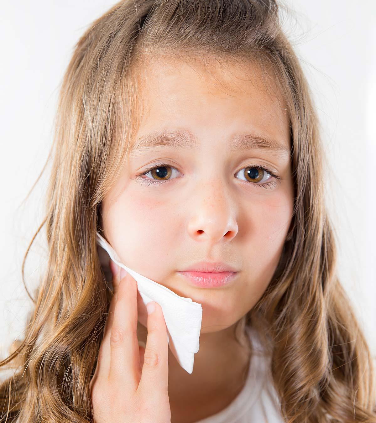 A small girl suffering from jaw pain