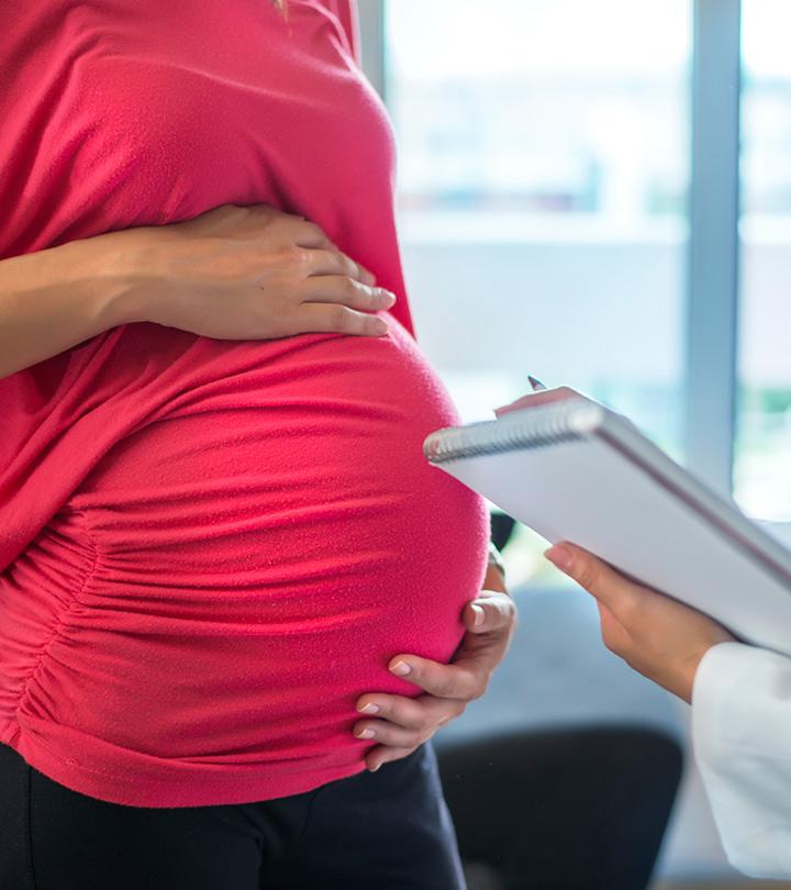 A pregnant lady holds her womb