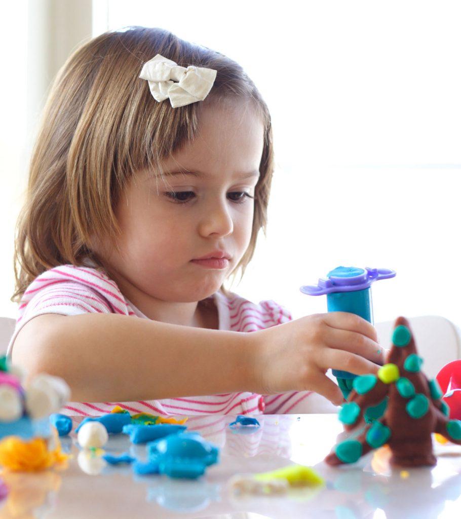 Plasticine modeling clay in children class. kids together play dough and  mold from plasticine in kindergarten or preschool. Group of four people.  Teaching modeling. They learn to live in a team. Stock