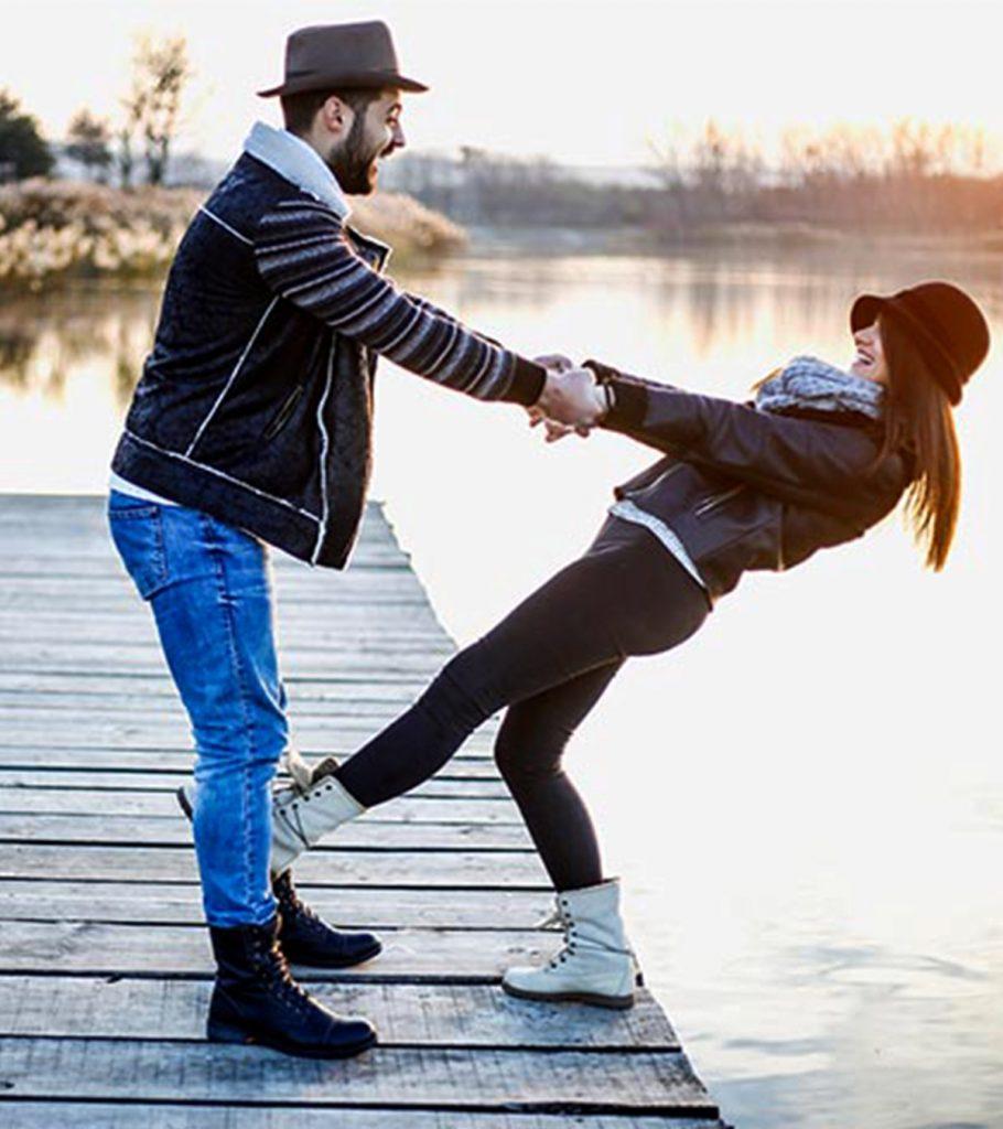 Building Trust. Man hanging woman off a dock