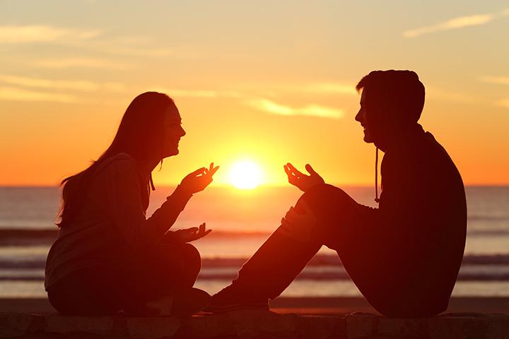 photo of two people having a conversation during sunset