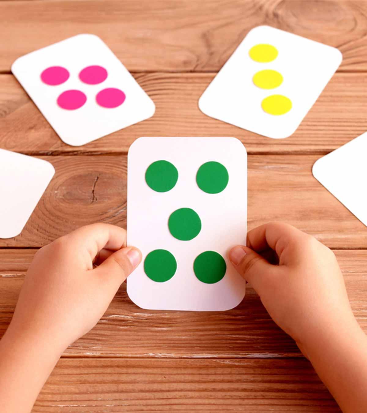 A small kid holds some cards