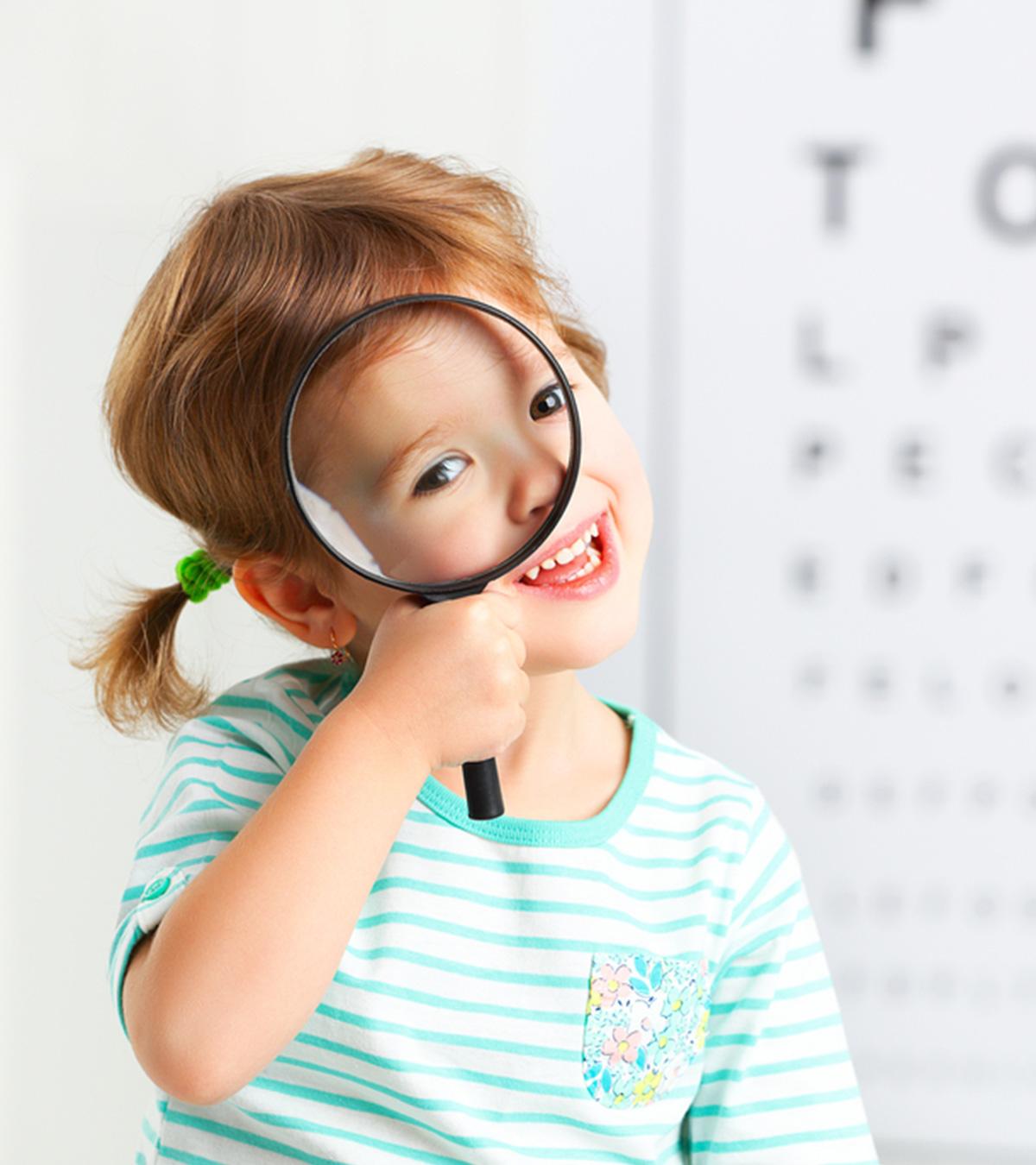 A kid holds a magnifying glass