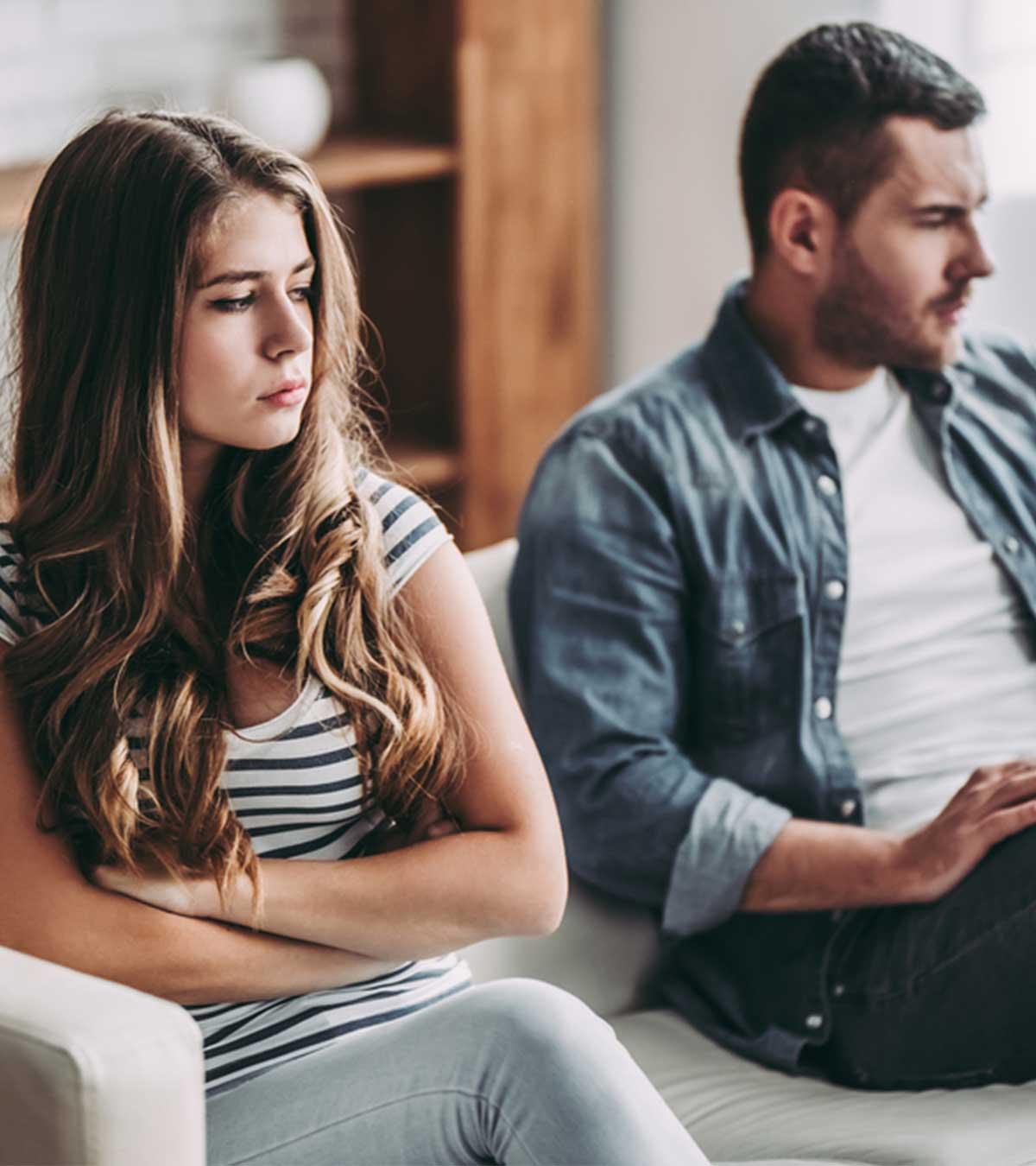 A couple sitting on a sofa in a sad mood
