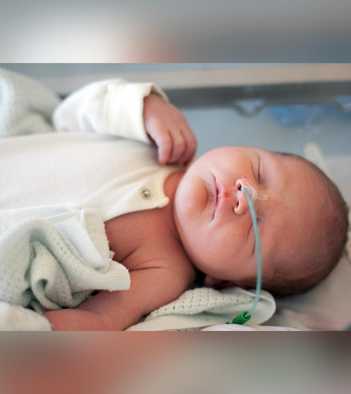 An infant taking food from the tube