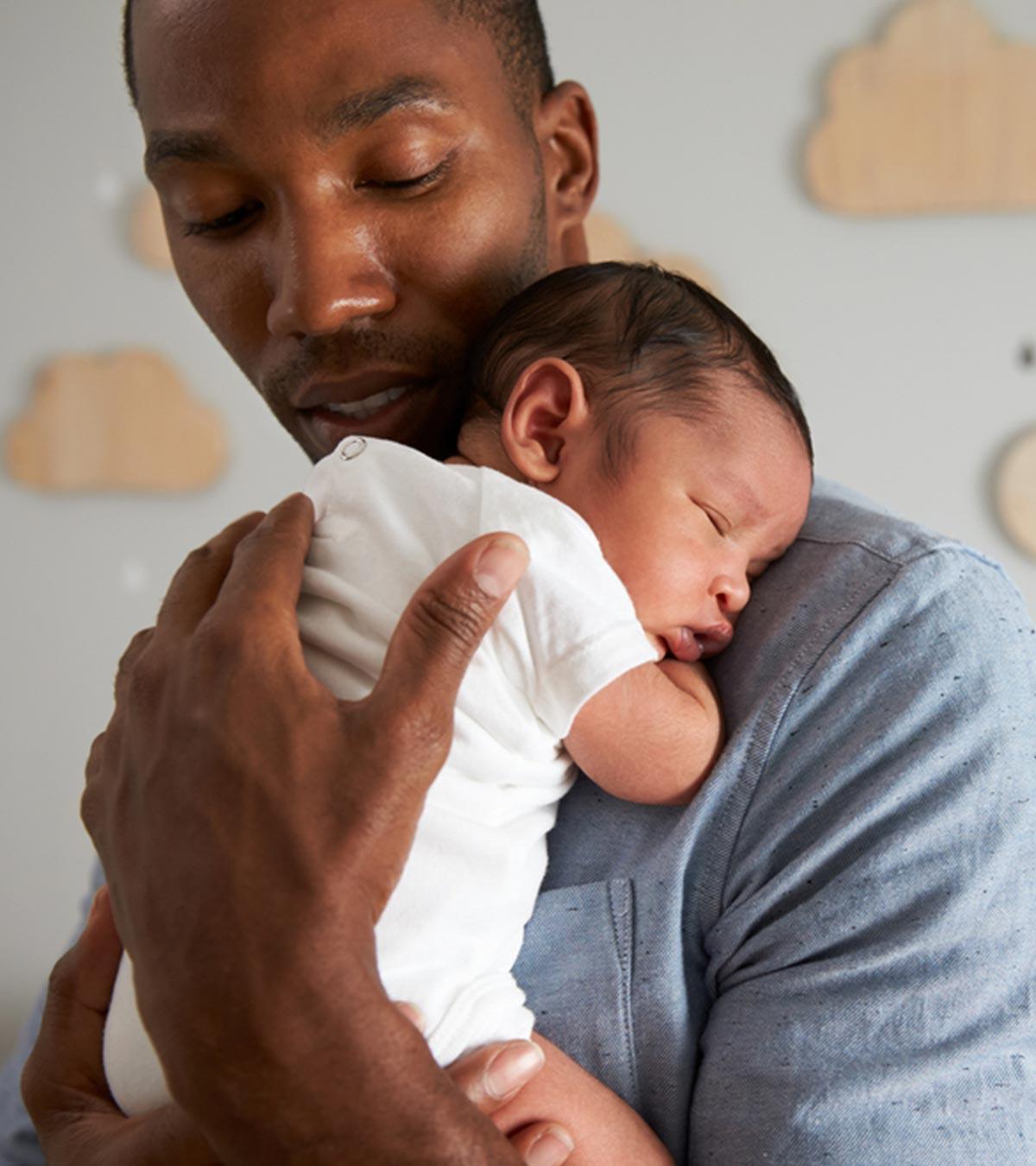 A father holds his baby on his shoulder