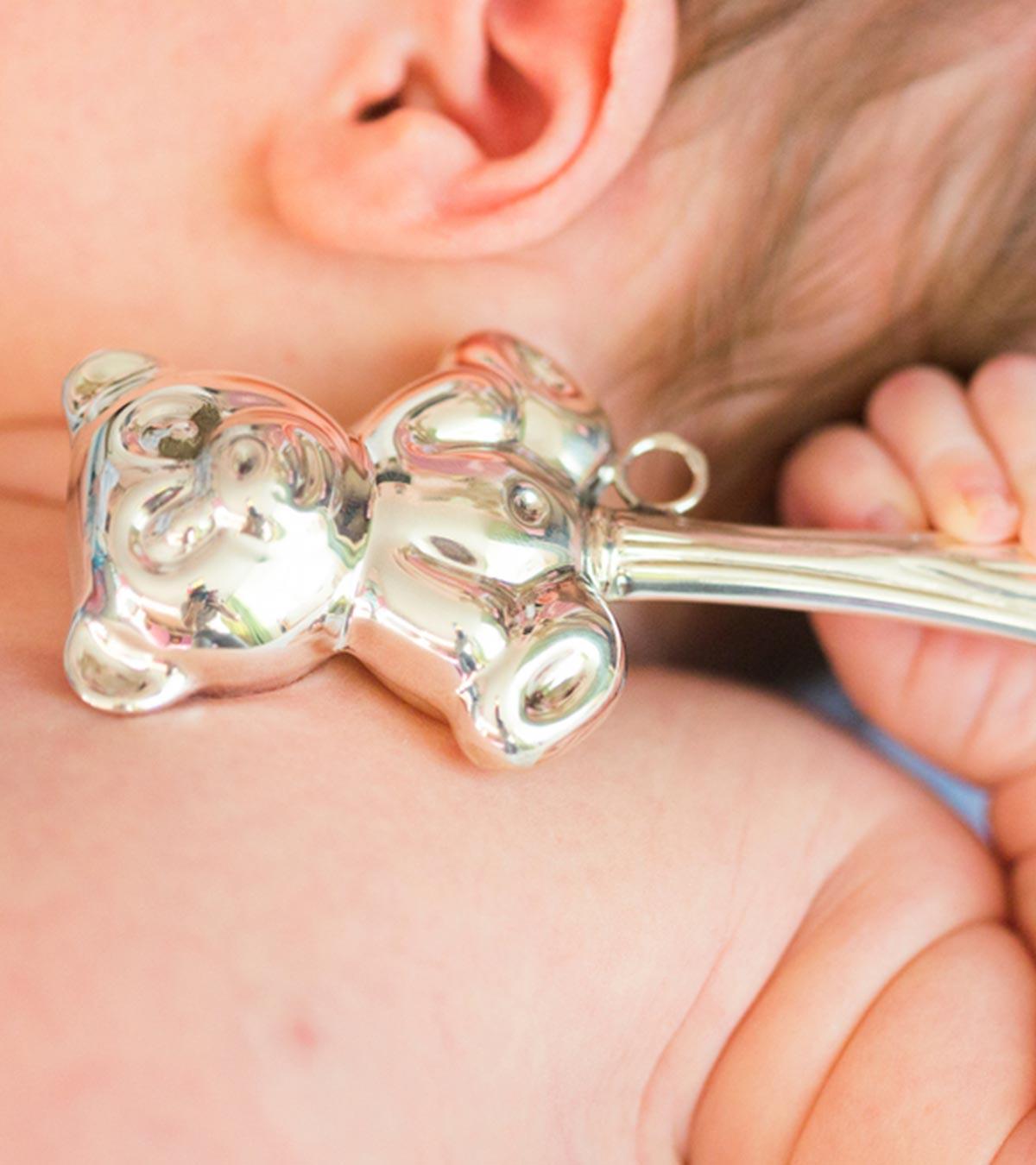 A Baby Holding Silver Utensil