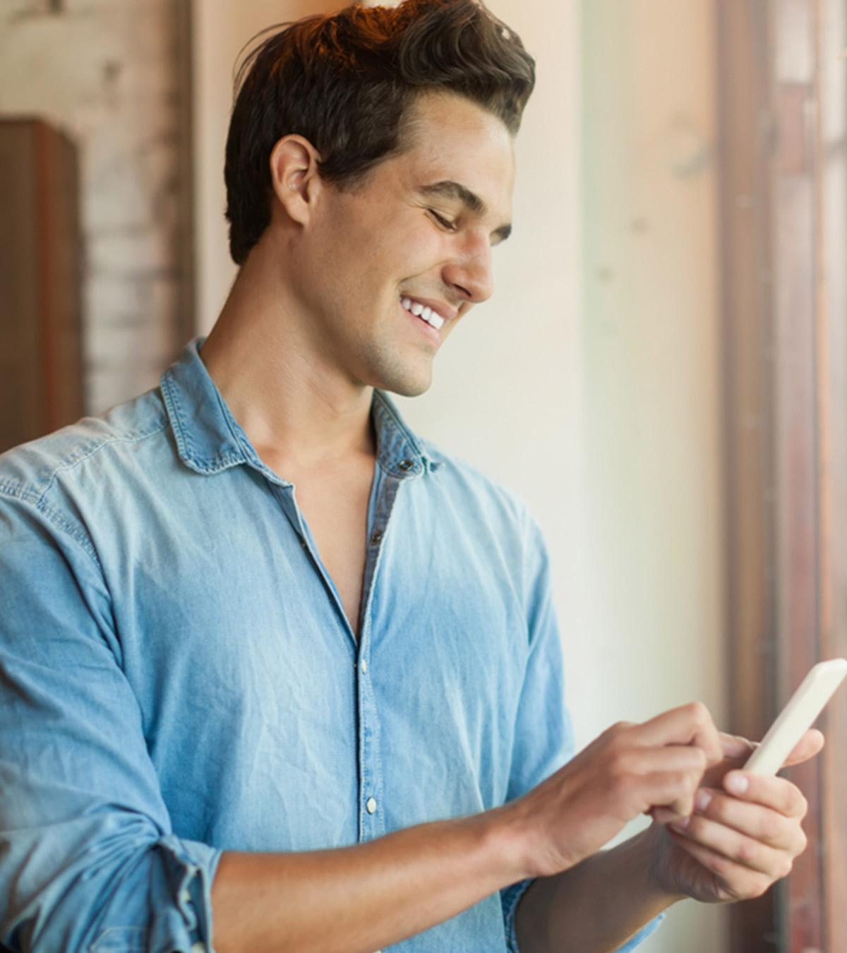 Man happily reading a text message from a girl