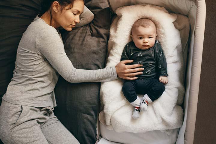 Baby sleeps an arm away from parents