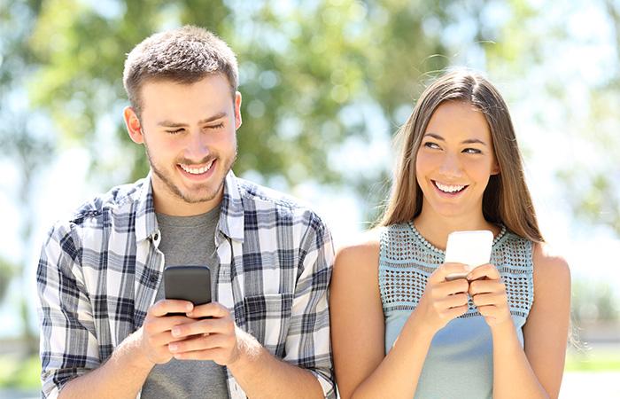 Happy boyfriend and girlfriend playing video games and holding